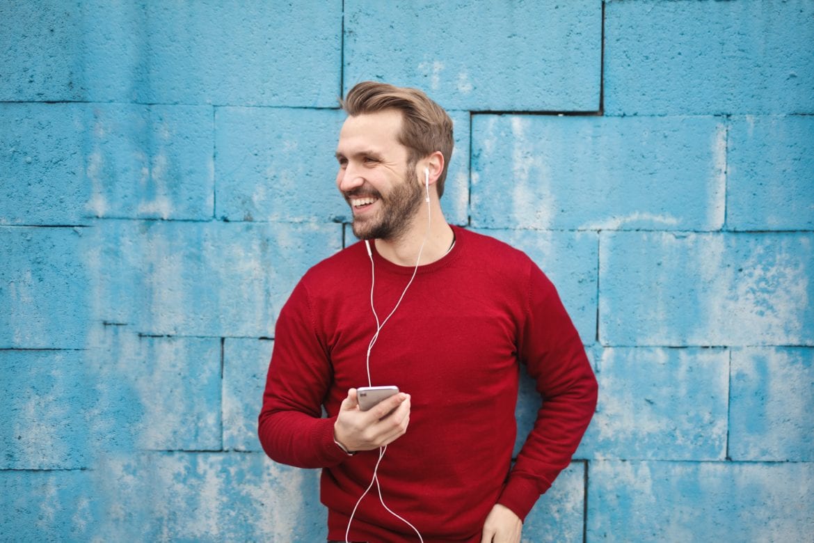 man using smartphone with earbuds