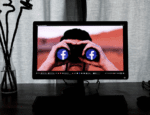 monitor with image of man using binoculars