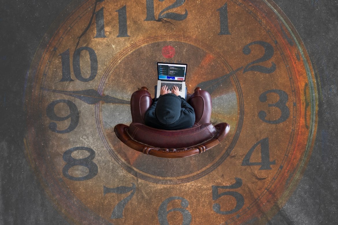 person using laptop while sitting on clock face